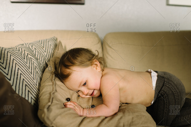 Toddler Lying Down On The Couch And Smiling Stock Photo Offset