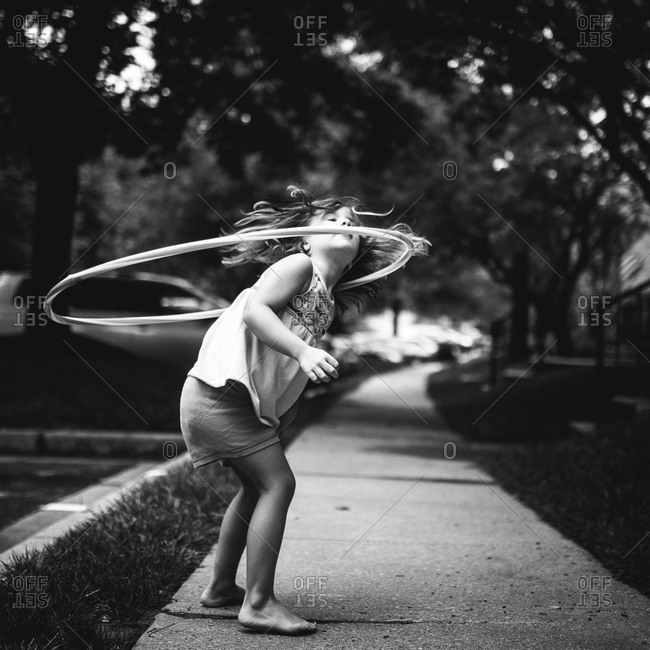 Girl twirling a hula hoop around her neck