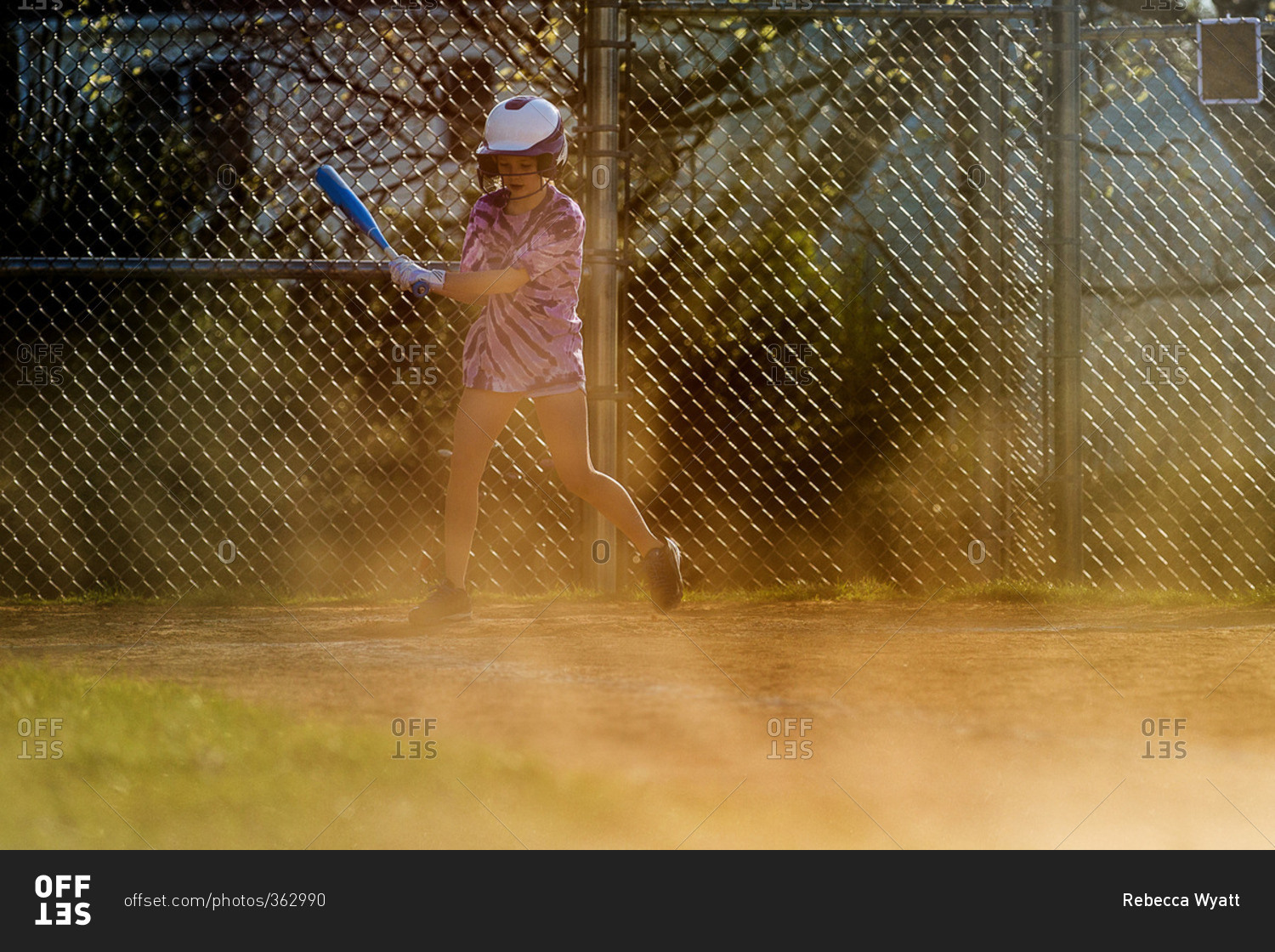 Girl swinging bat while playing softball
