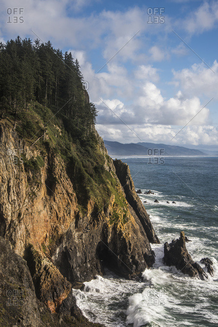 Scattered clouds pass over the Oregon coast; Manzanita, Oregon, United States of America