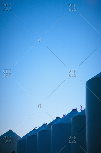 A row of silos against a blue sky; Saskatchewan, Canada