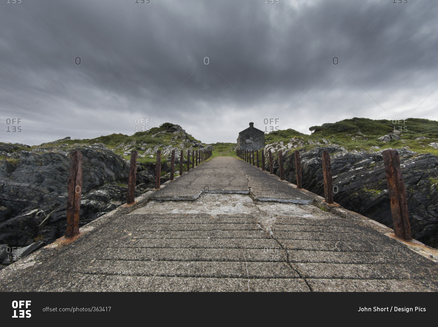 Broken, worn and weathered concrete path under storm clouds; Argyll and Bute, Scotland
