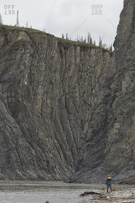 Man standing at the mouth of the Peel Canyon along the Peel River, part of the Peel Watershed; Yukon, Canada