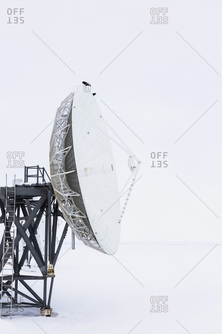 A large satellite dish points out to barren sea ice, Barrow, North Slope, Arctic Alaska, USA, Winter