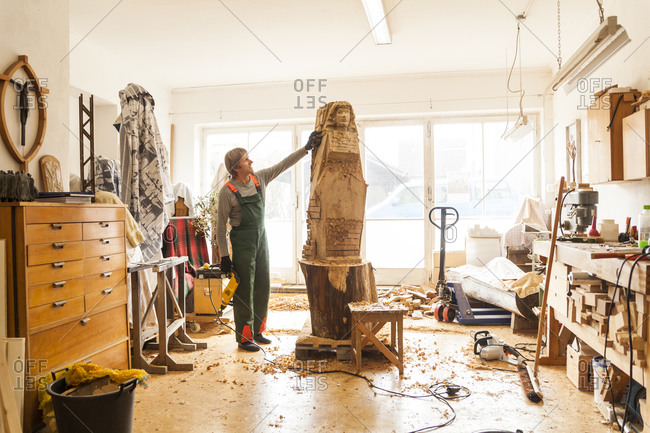 Wood carver in workshop working on sculpture
