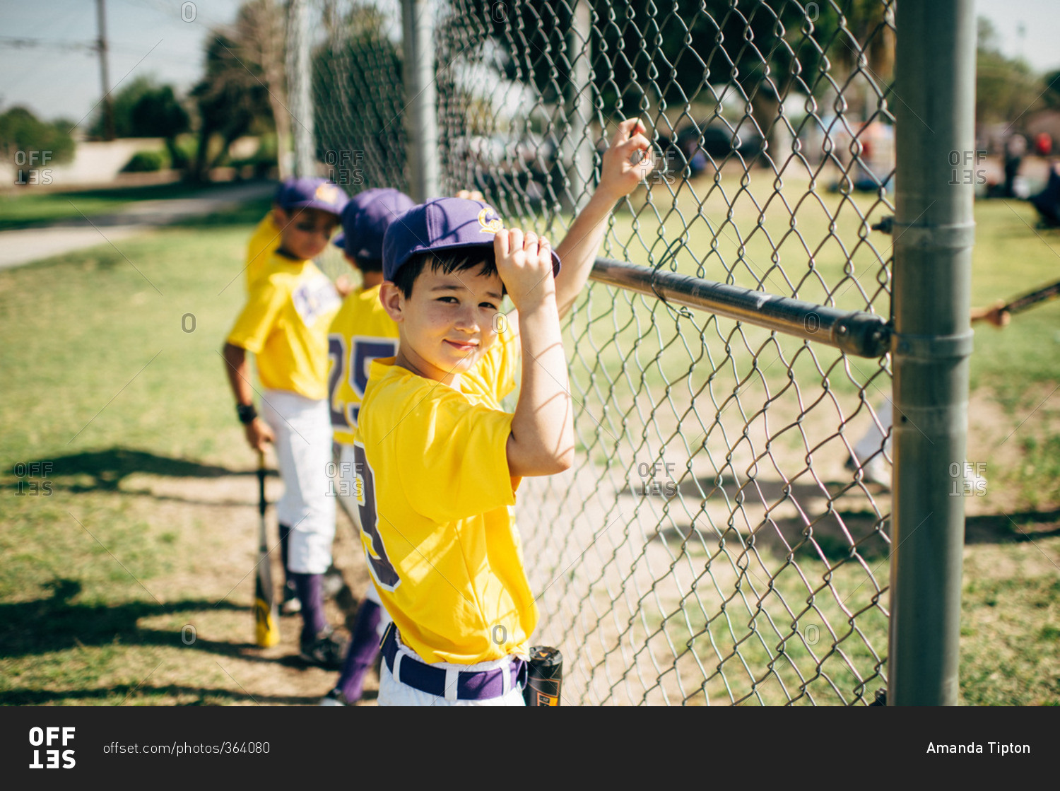 Boys on a baseball team standing by a fence
