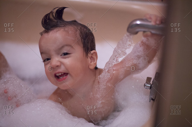 Toddler boy playing in bubble bath