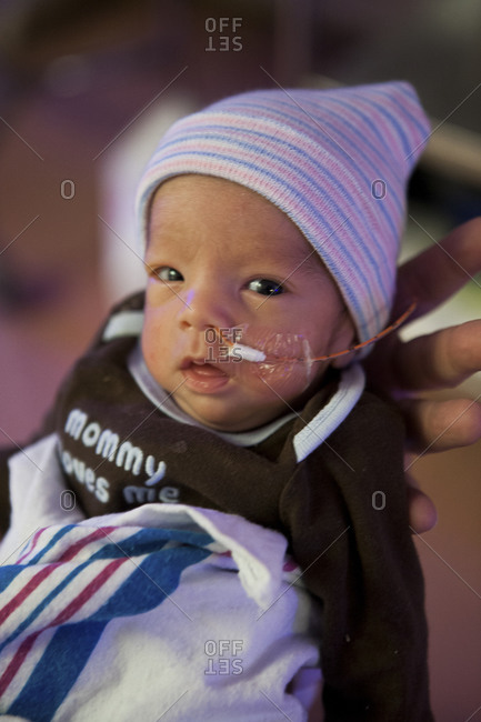 Parent holding a premature infant in the NICU