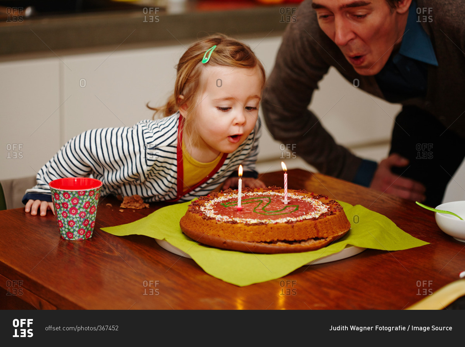Young girl blowing out birthday candles on cake