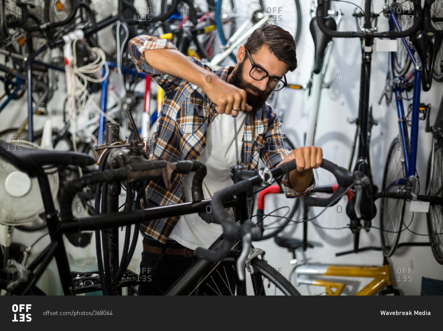 Bike mechanic checking at bicycle in bike repair shop