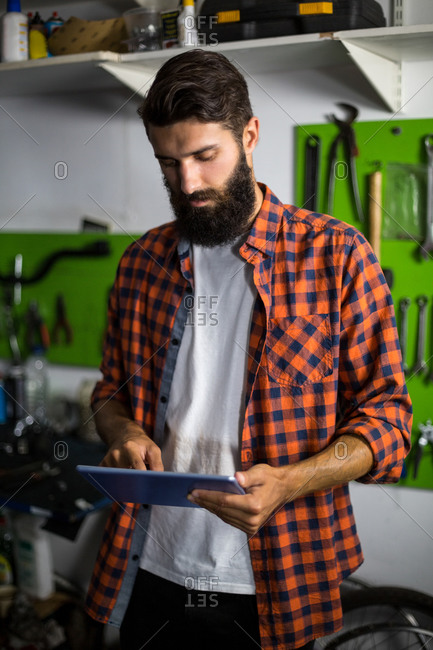 Bike mechanic using tablet computer in bike repair shop