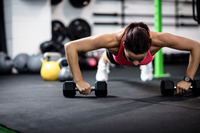 Woman exercise with dumbbells and working on her biceps at gym stock photo  - OFFSET