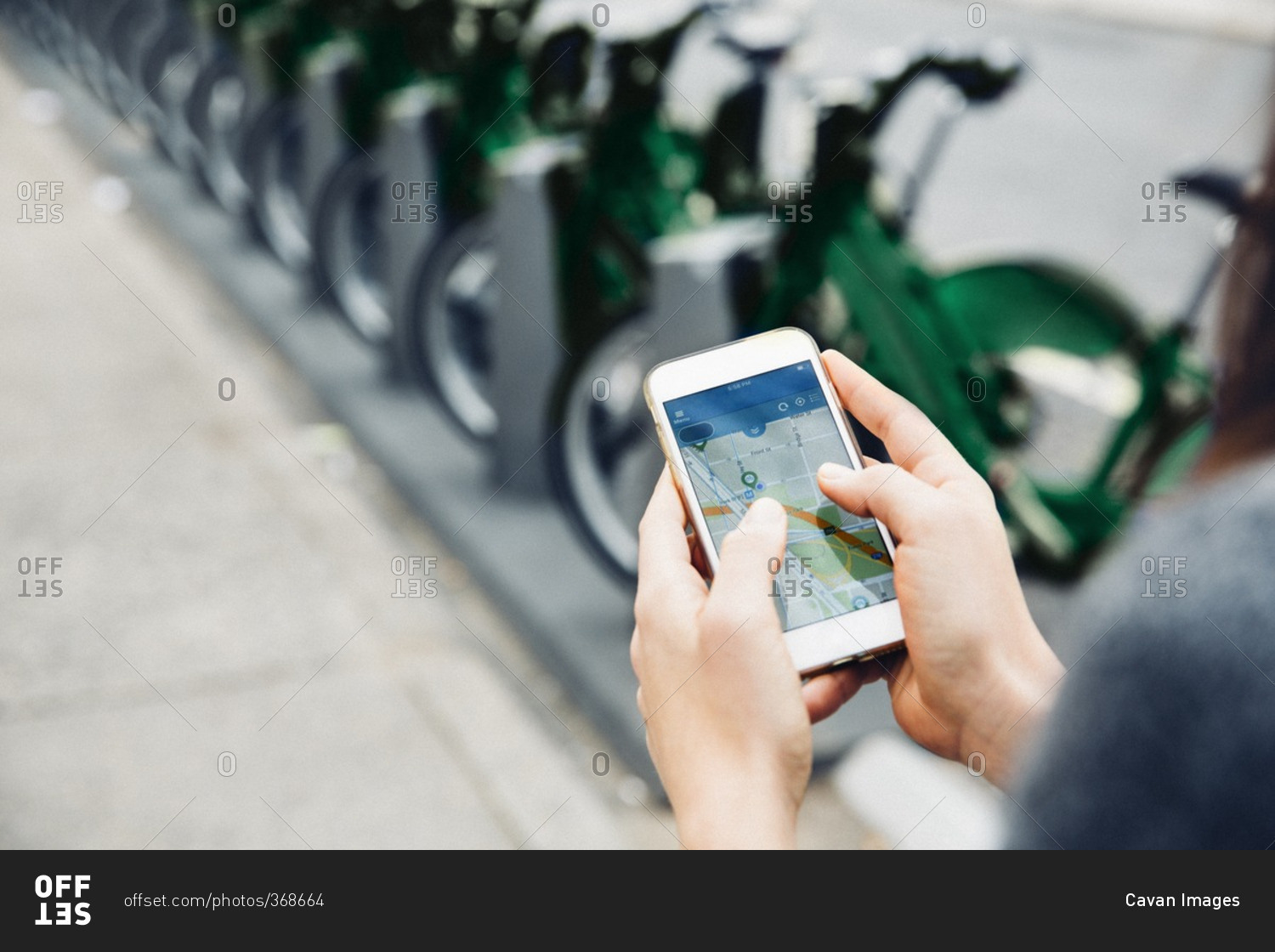 High angle view of woman using smart phone by bicycle rack on street