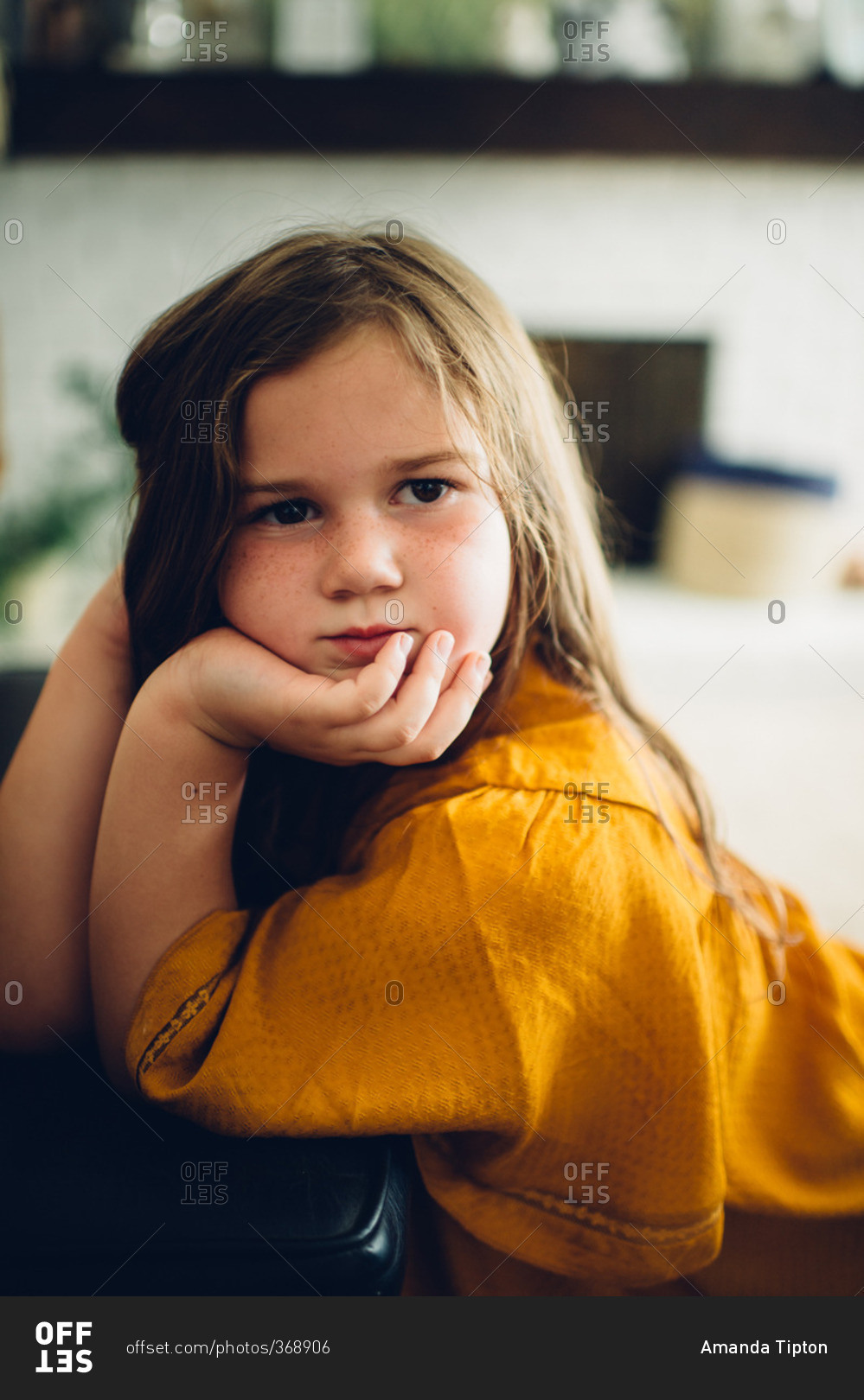 Little girl sitting on the floor resting on a piano bench