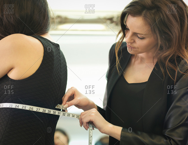 Fashion designer measuring clothing in fashion design studio
