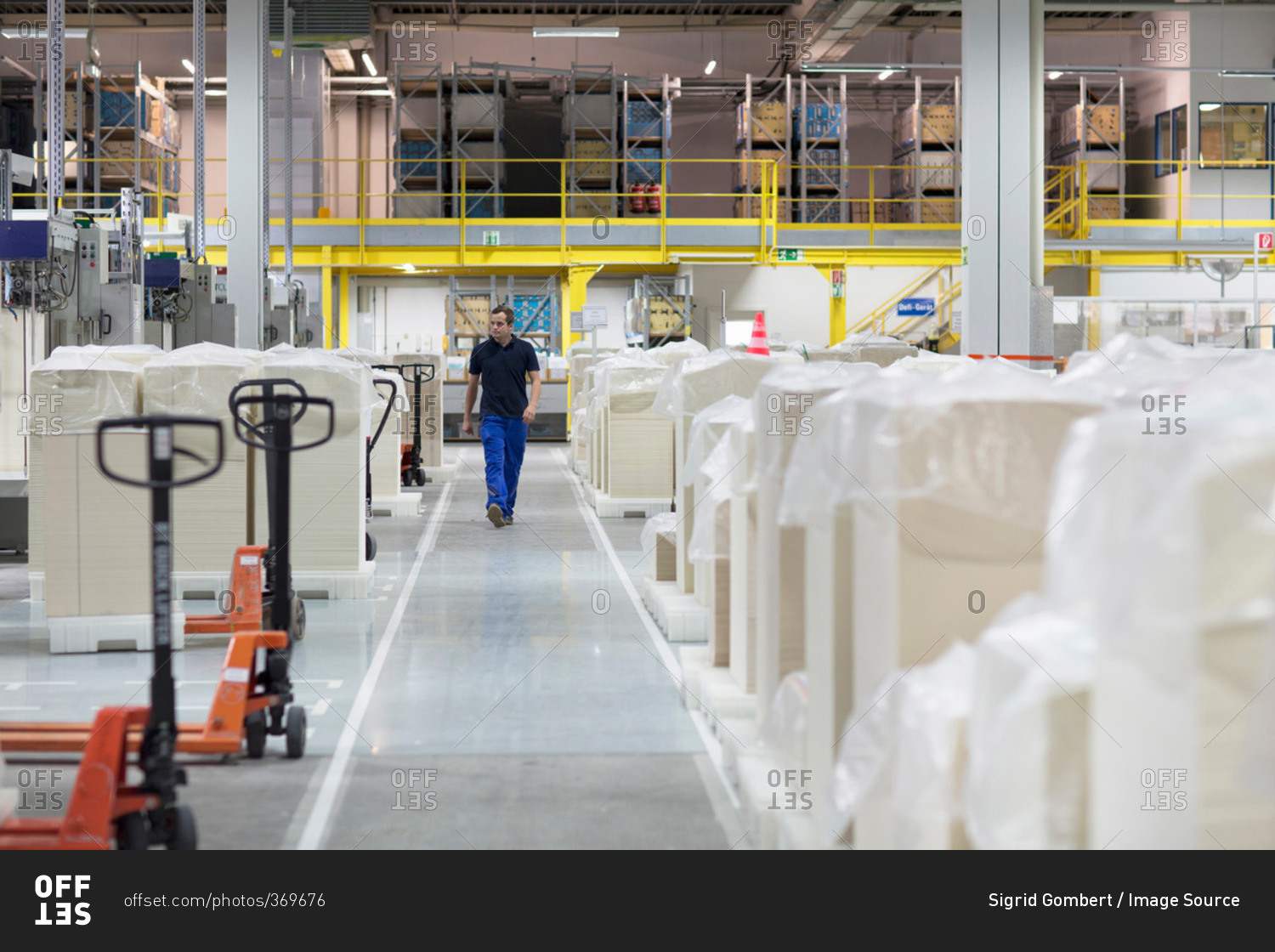 Worker walking through paper packaging factory