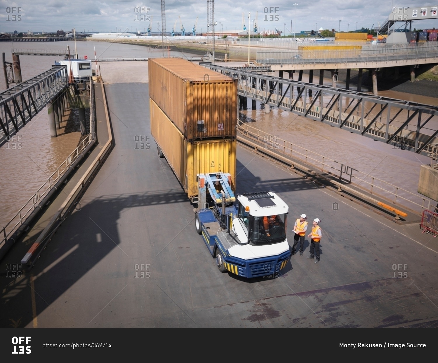 Elevated view of shipping container and truck on ramp to ship