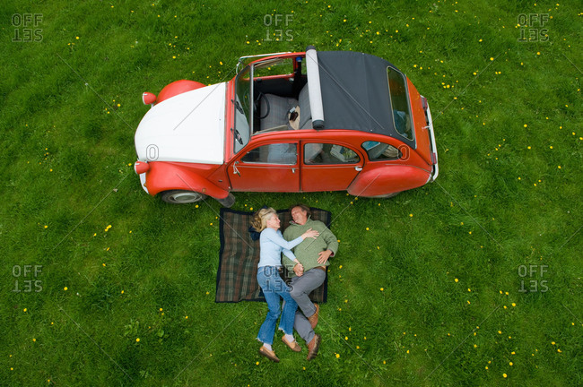 Cherington, United Kingdom - May 8, 2014: Overhead view of mature couple relaxing on picnic blanket