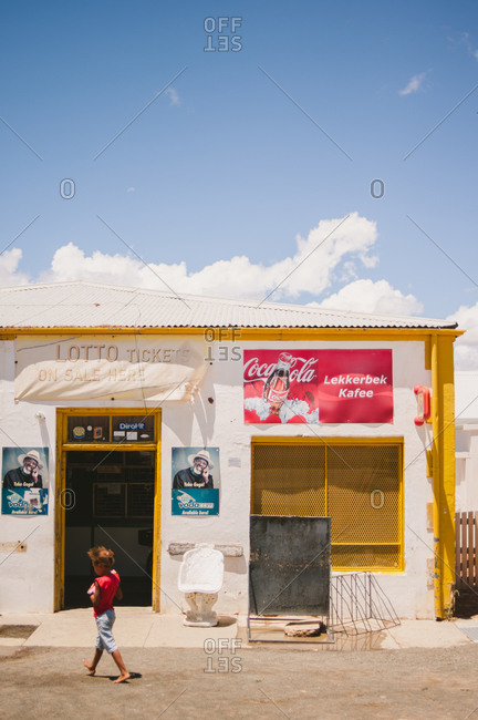 Karoo, South Africa - January 7, 2014: Girl walking by a convenient store