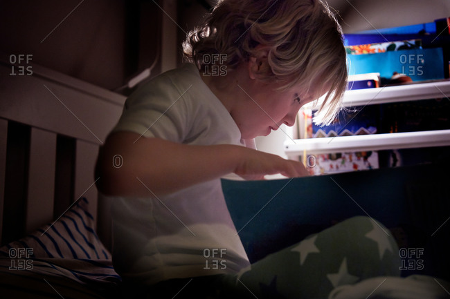 Child reading on bed