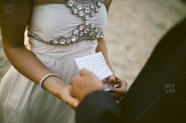 A Bride And Groom Read Their Vows During A Beach Wedding