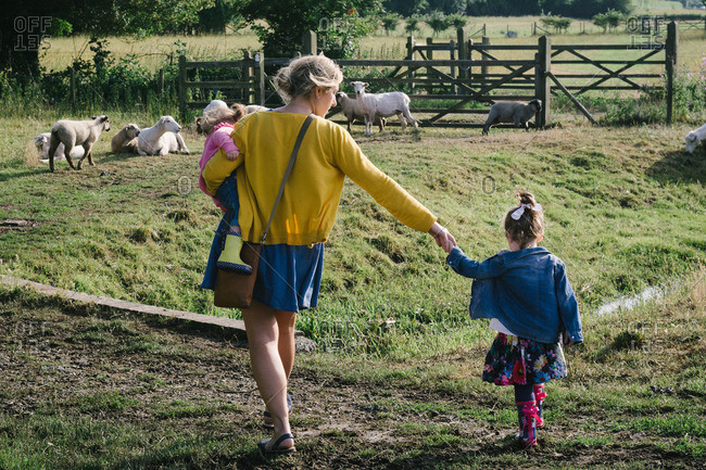 Mother walking with two daughters on a farm