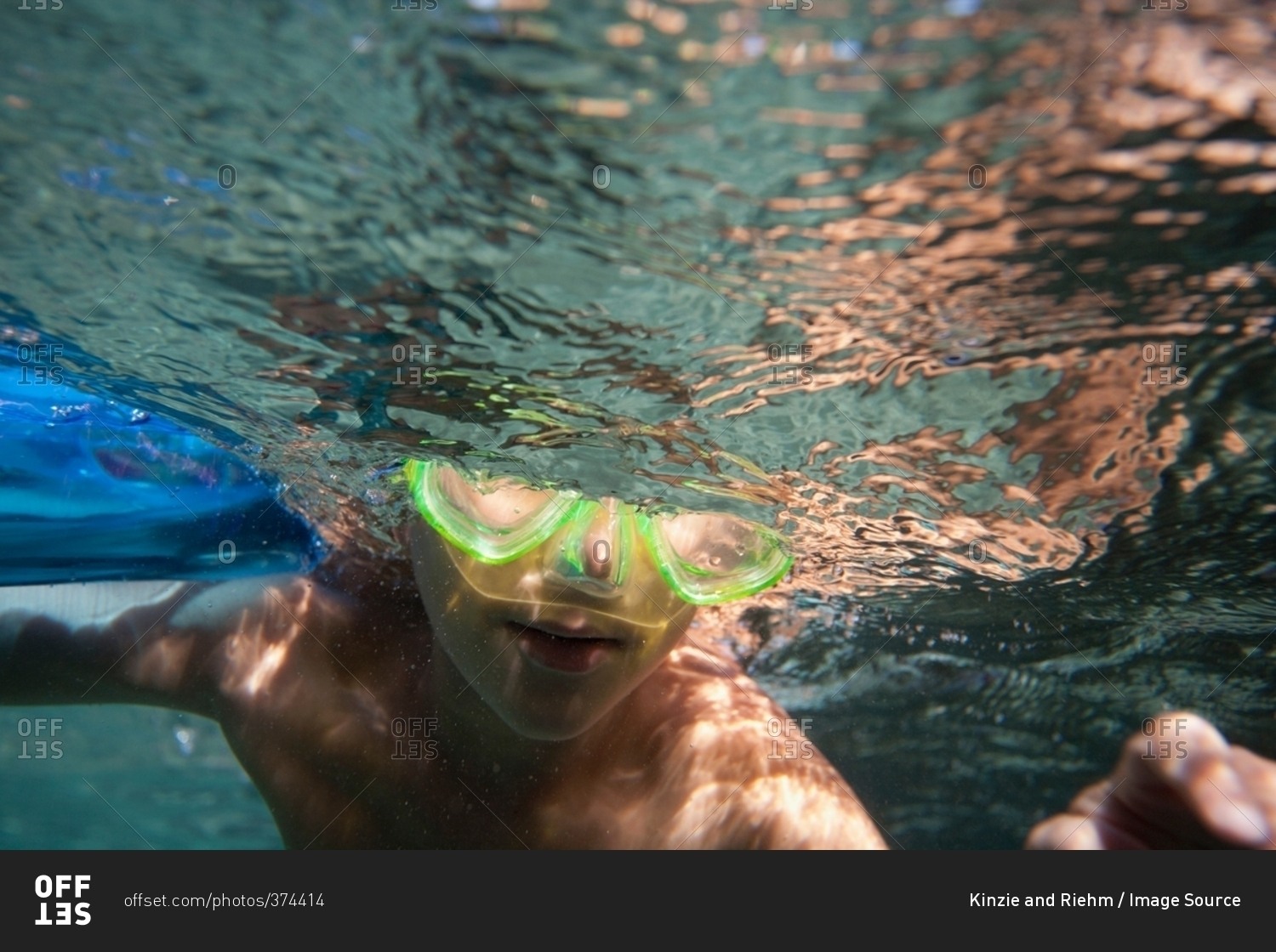 Underwater view of boy wearing goggles swimming underwater