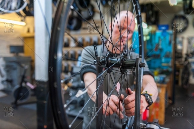 Mechanic repairing bicycle in workshop