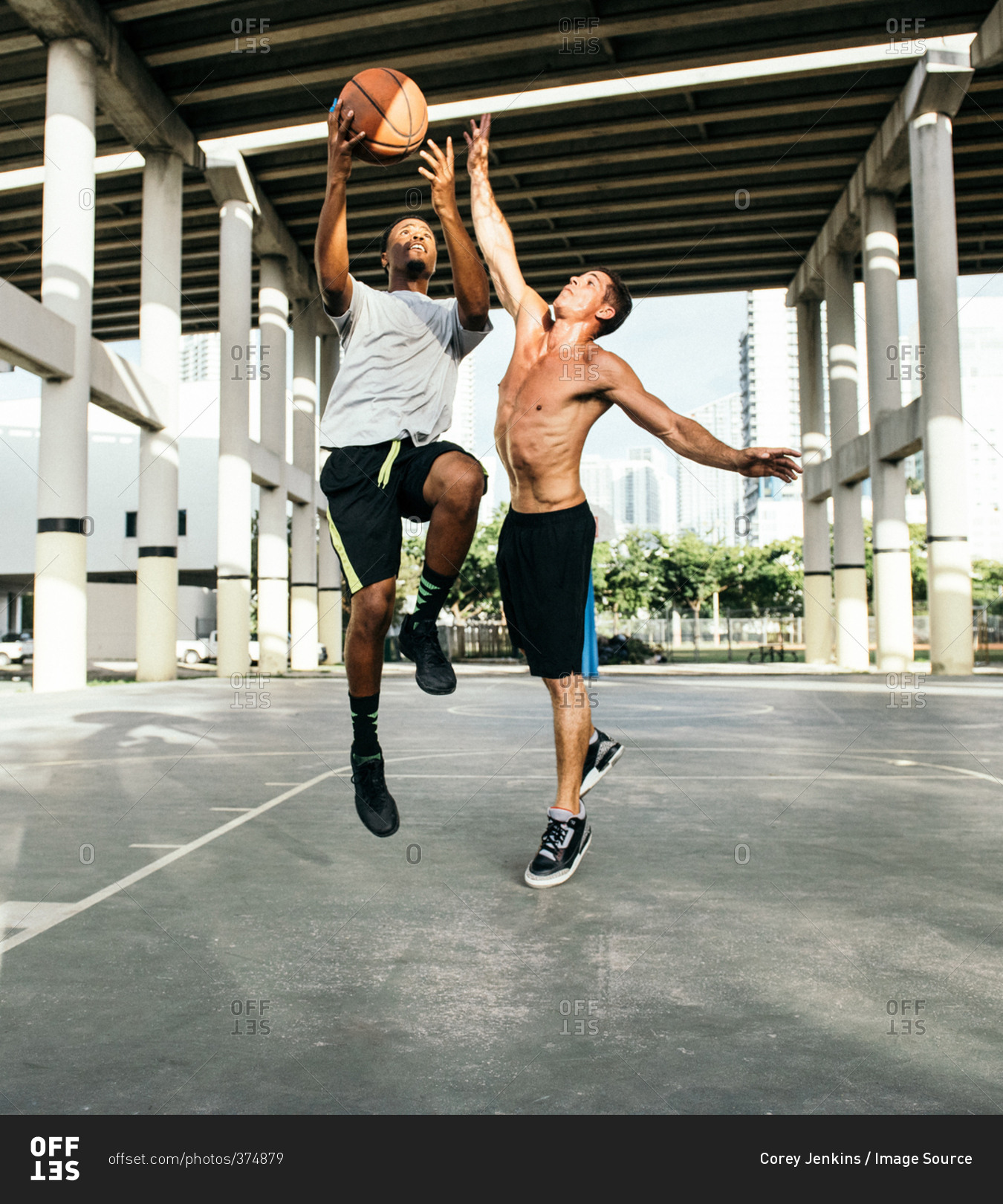 Men on basketball court jumping for basketball