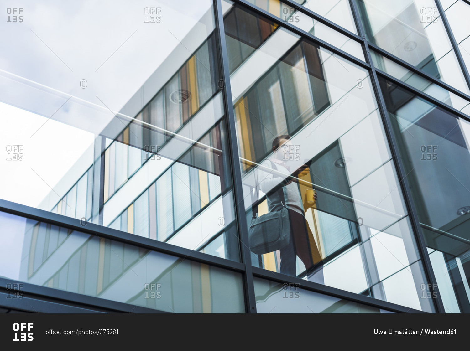 Businessman with mobile phone, standing in passage