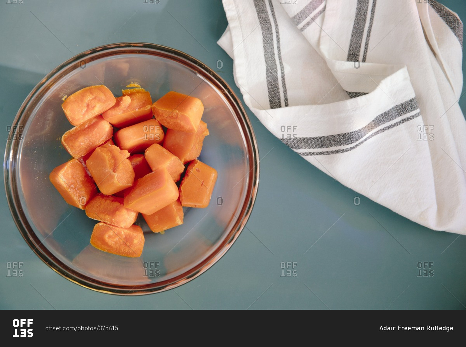 Bowl full of frozen cubes of homemade baby food made from carrots