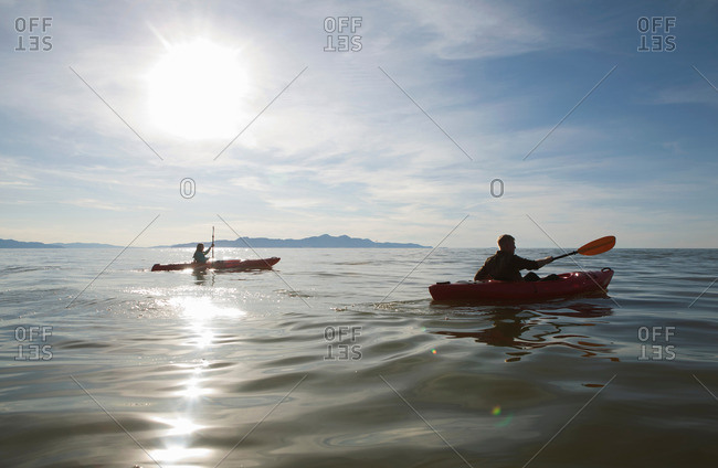 Couple kayaking, sunlight reflecting on water, Great Salt Lake, Utah, USA