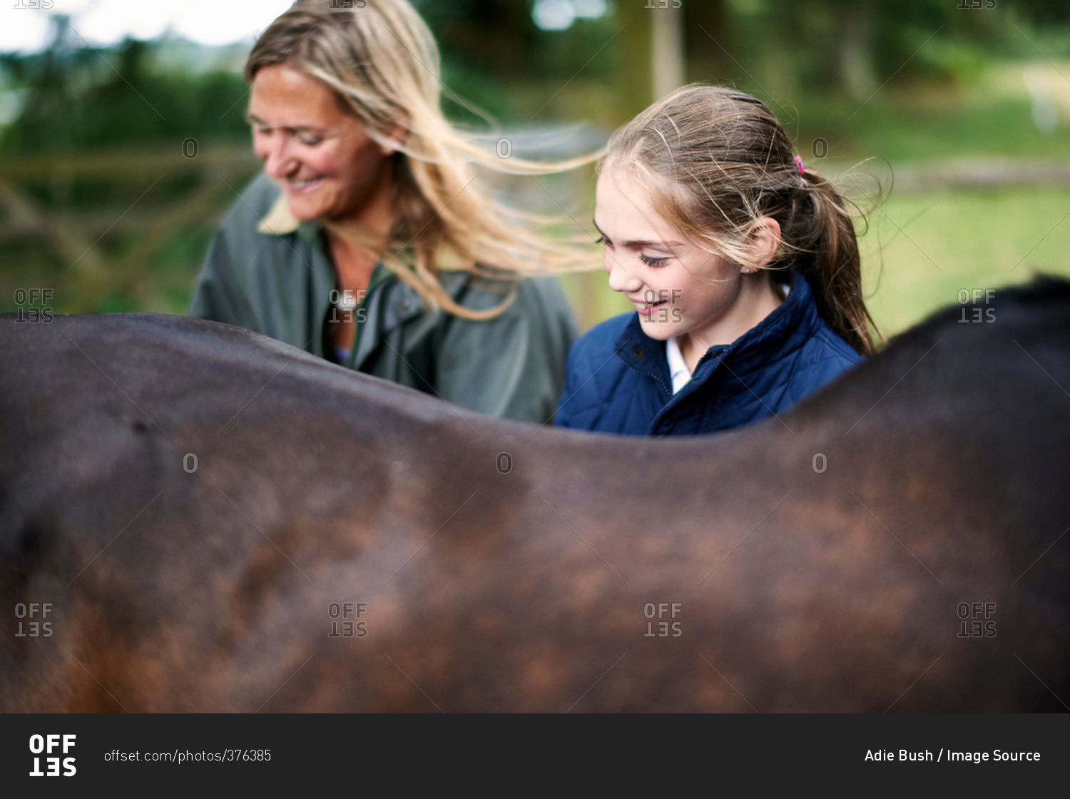 Girl and mother tending horse