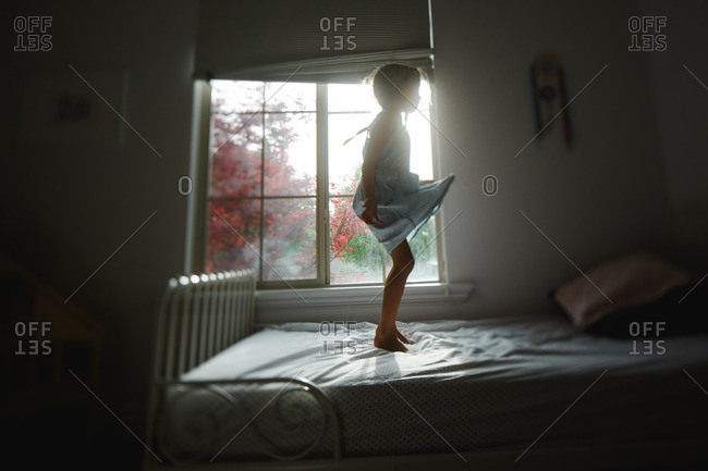 Girl jumping on her bed