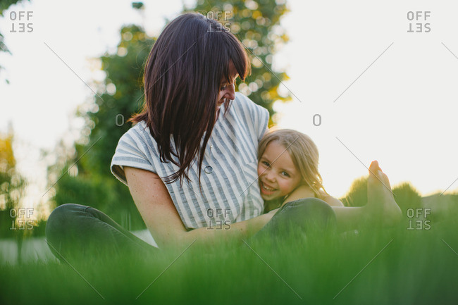 Mother and daughter sitting together in the grass