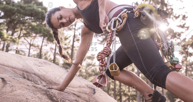 Portrait of woman is climbing on a rock in the wood