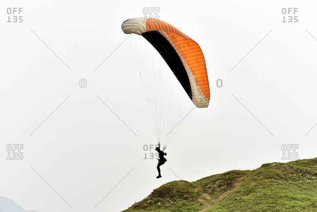 Man paragliding in silhouette