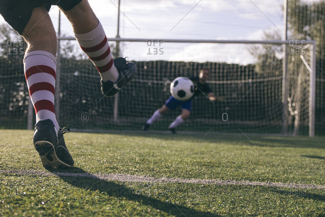 Legs Of A Soccer Player Kicking A Ball In Front Of A Goal With A Goalkeeper Stock Photo Offset