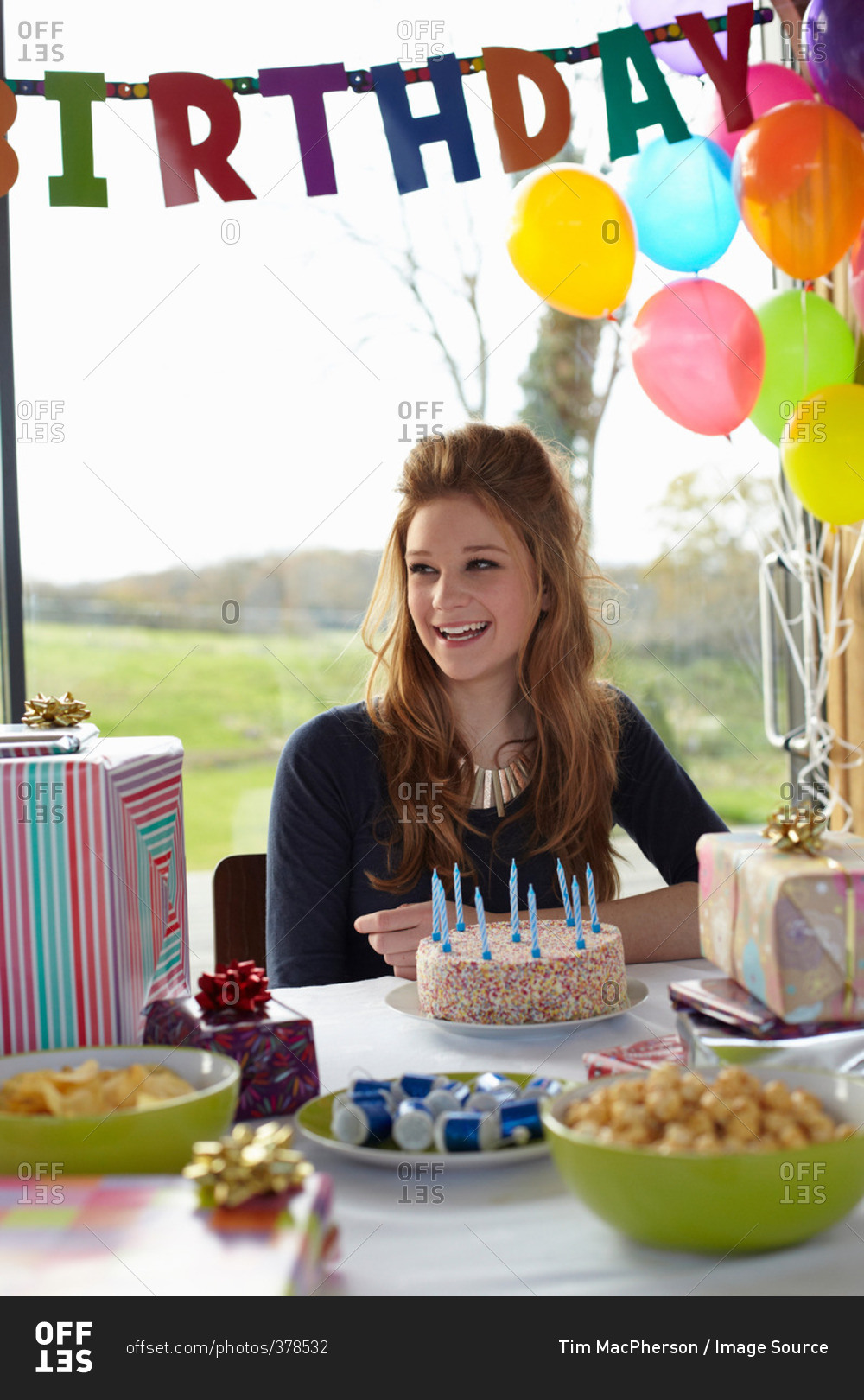 Teenage girl at table with birthday cake