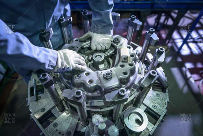 Close up of engineer assembling industrial clutch on assembly line