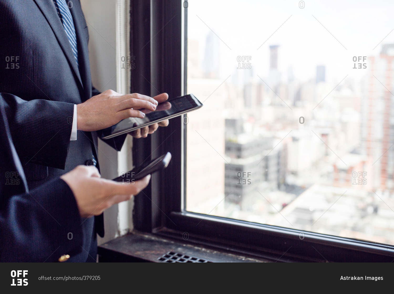 Cropped image of businessman and businesswoman using technologies by window