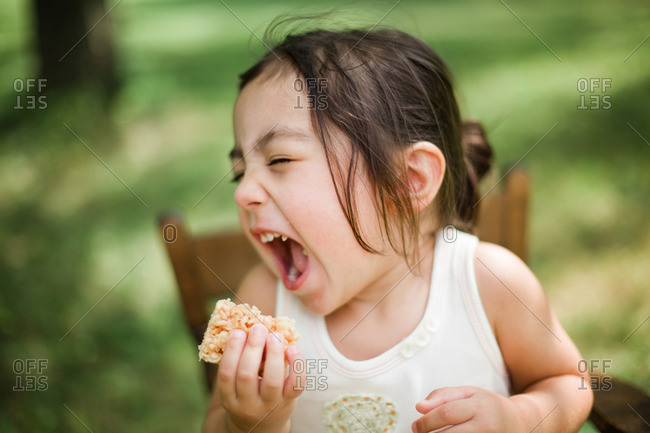 Happy young girl singing with her snack