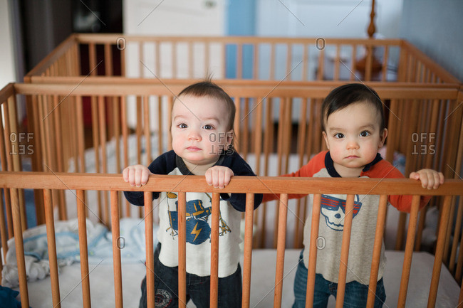 Twin toddler boys together in crib