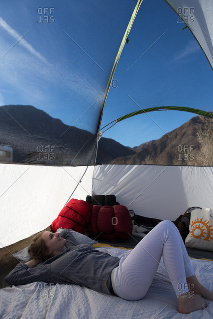 Young woman looking out at view from tent, Anza-Borrego Desert State Park, California, USA