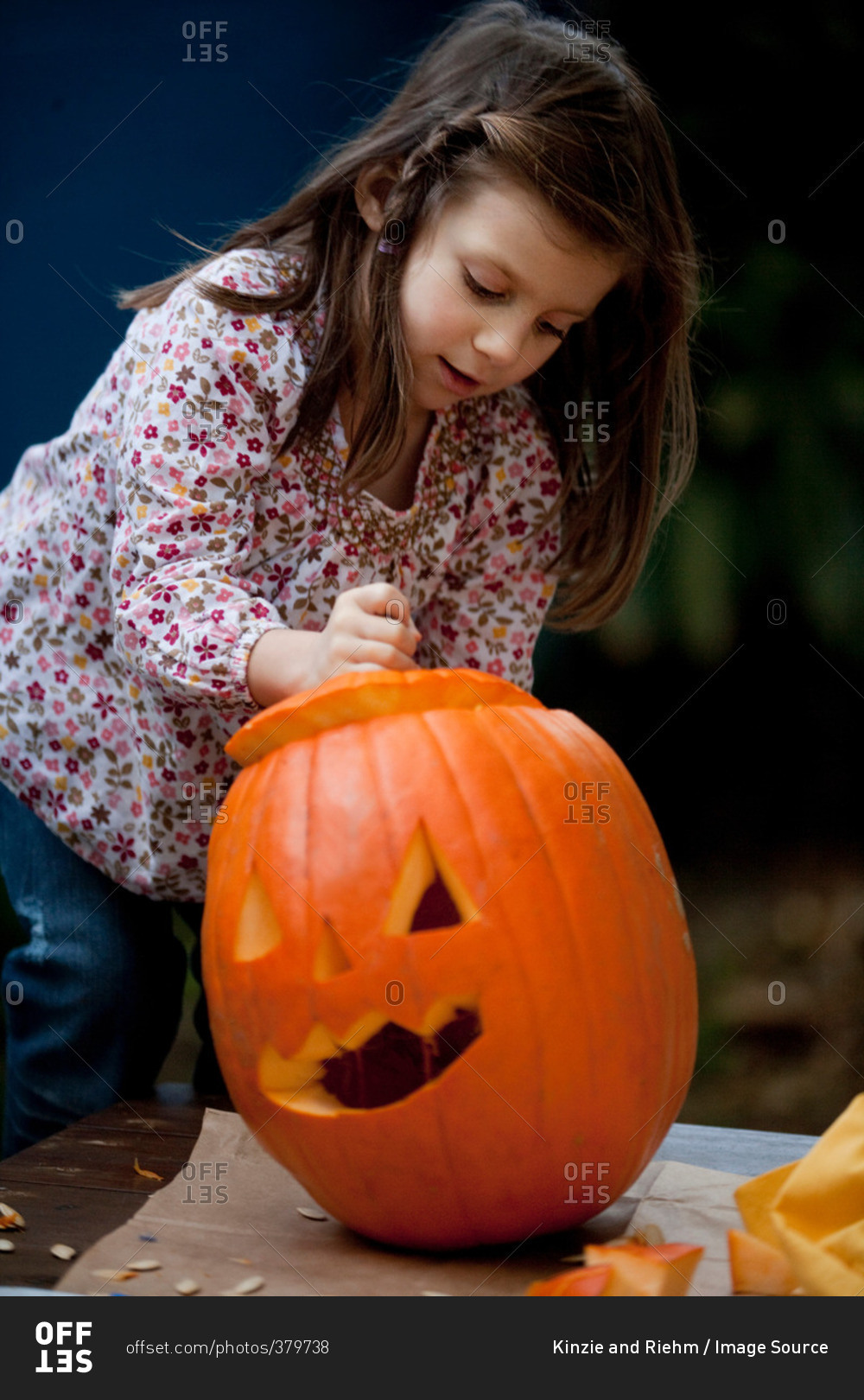 Young girl carving a pumpkin for Halloween