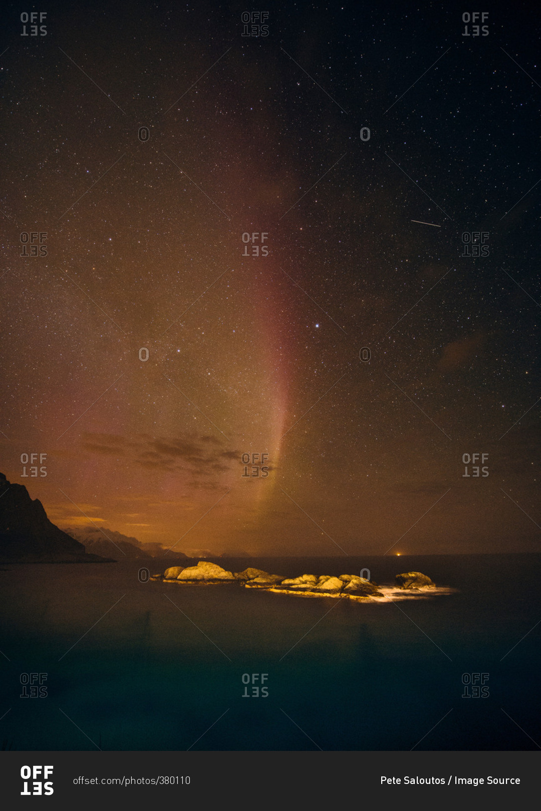 Aurora borealis disappearing over sea horizon, Reine, Norway
