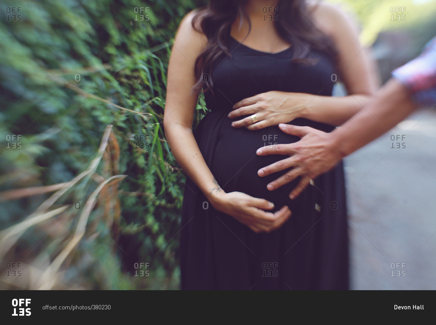 Portrait of a pregnant woman holding her abdomen