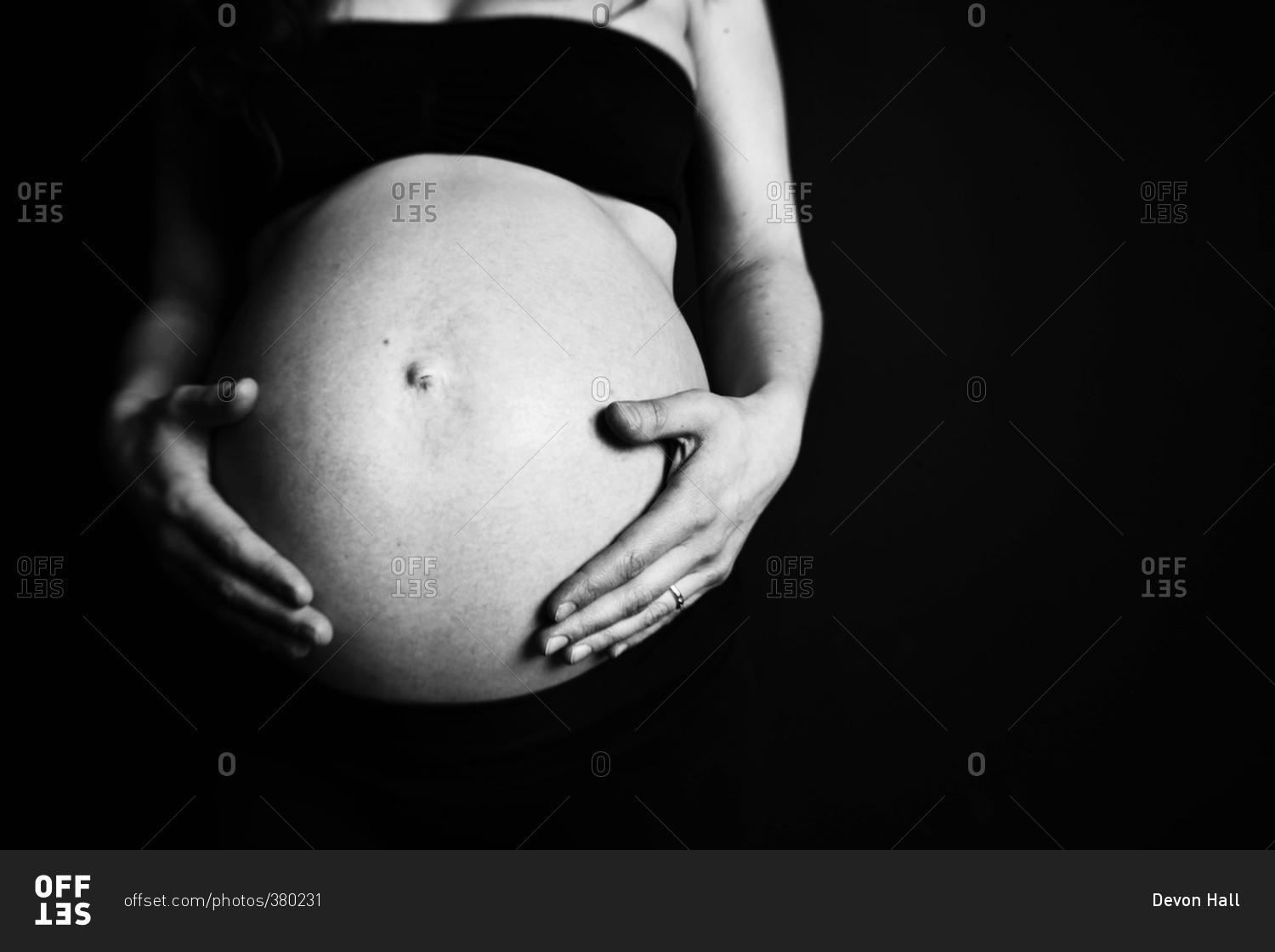 Close-up portrait of a pregnant woman holding her abdomen