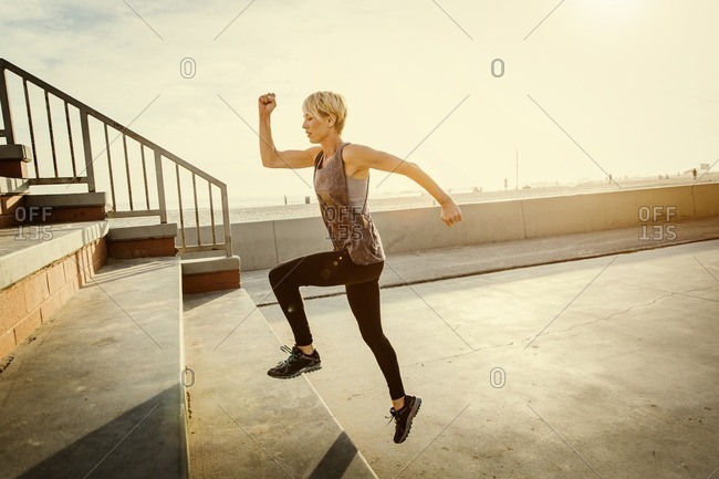 Woman doing a stair workout along a sunny beach