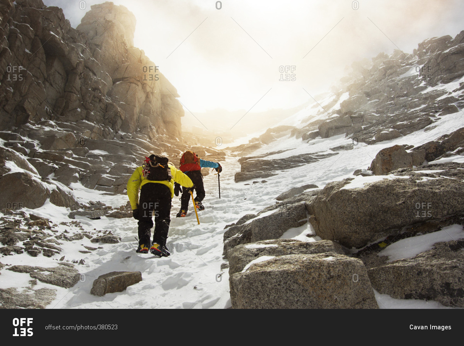 Low angle view of men hiking on snow covered Mount Whitney